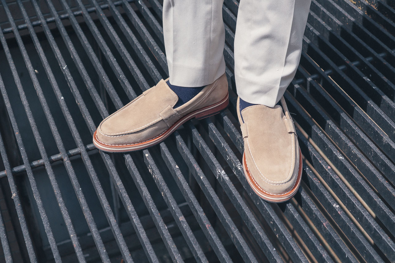 man wearing HELM boots loafers standing on a black grate