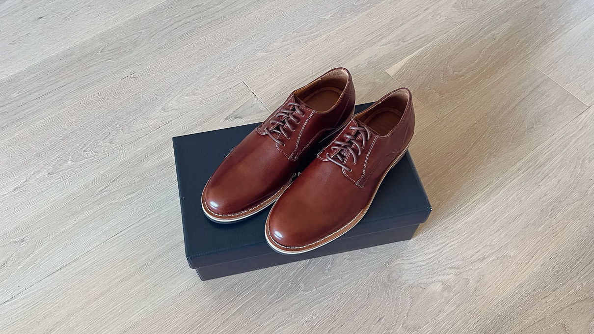 HELM boots Evans derbies on a dark blue shoe box sitting on a light wood floor