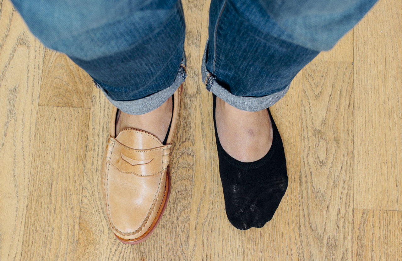 man with one shoe on, one shoe off, with no show socks