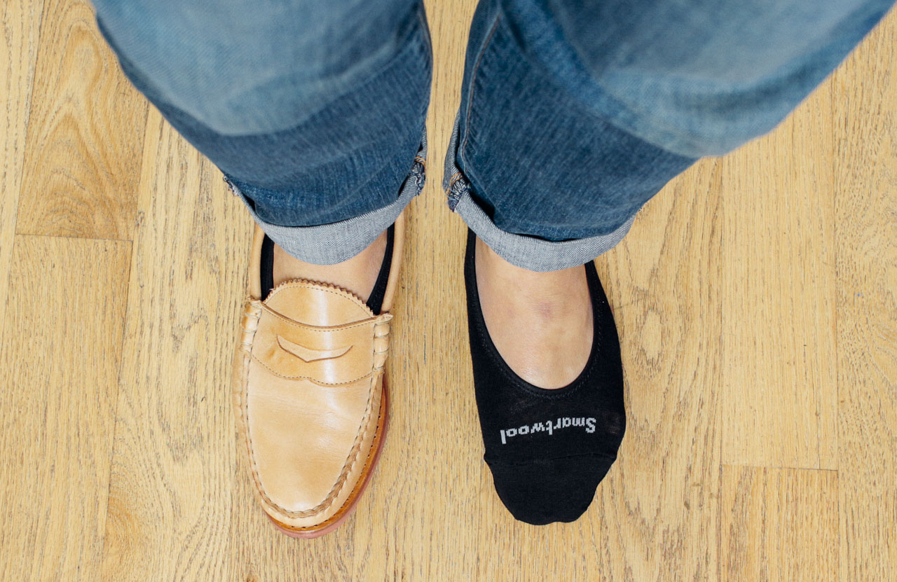 man with one shoe on, one shoe off, with no show socks