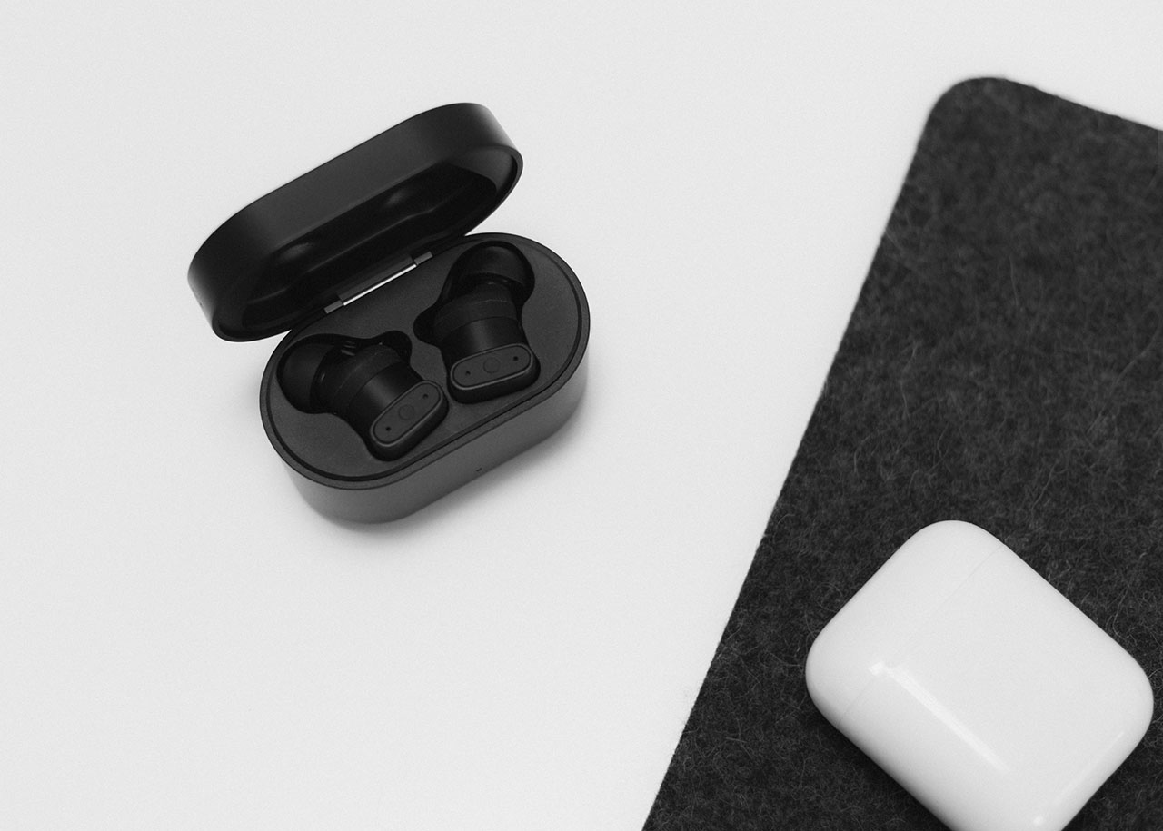 status audio between pro open case with ear buds next to airpods