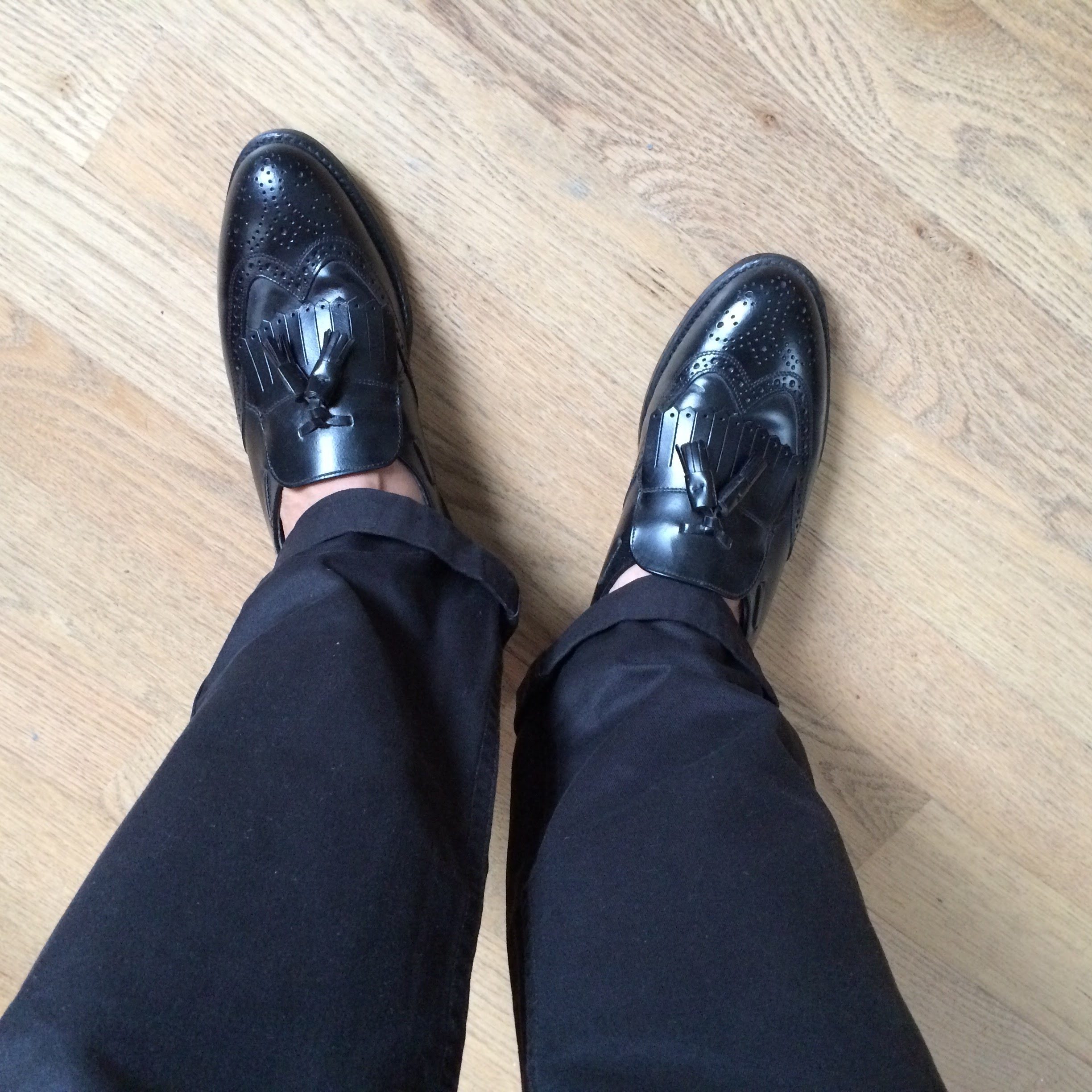 black leather wingtip kiltie tassel loafers.