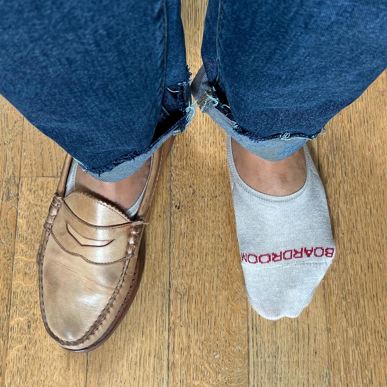 closeup of socks and loafers with one shoe on