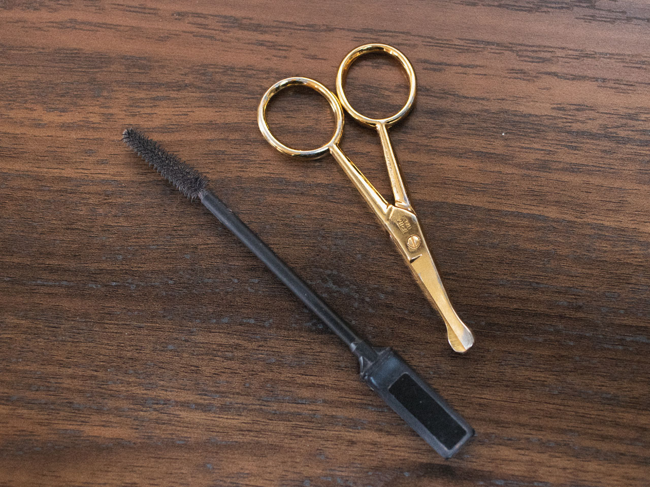 eyebrow brush and nose hair trimmers on wood table