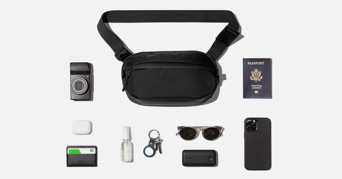 flatlay of the aer day sling 3 hip pack with everyday carry items