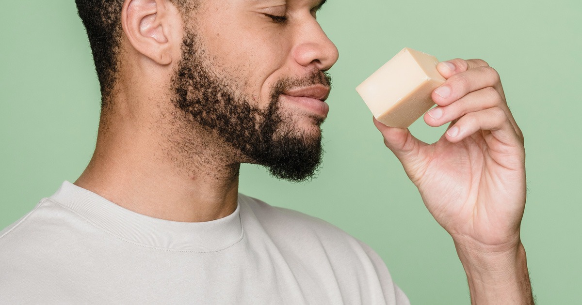 man smelling soap bar