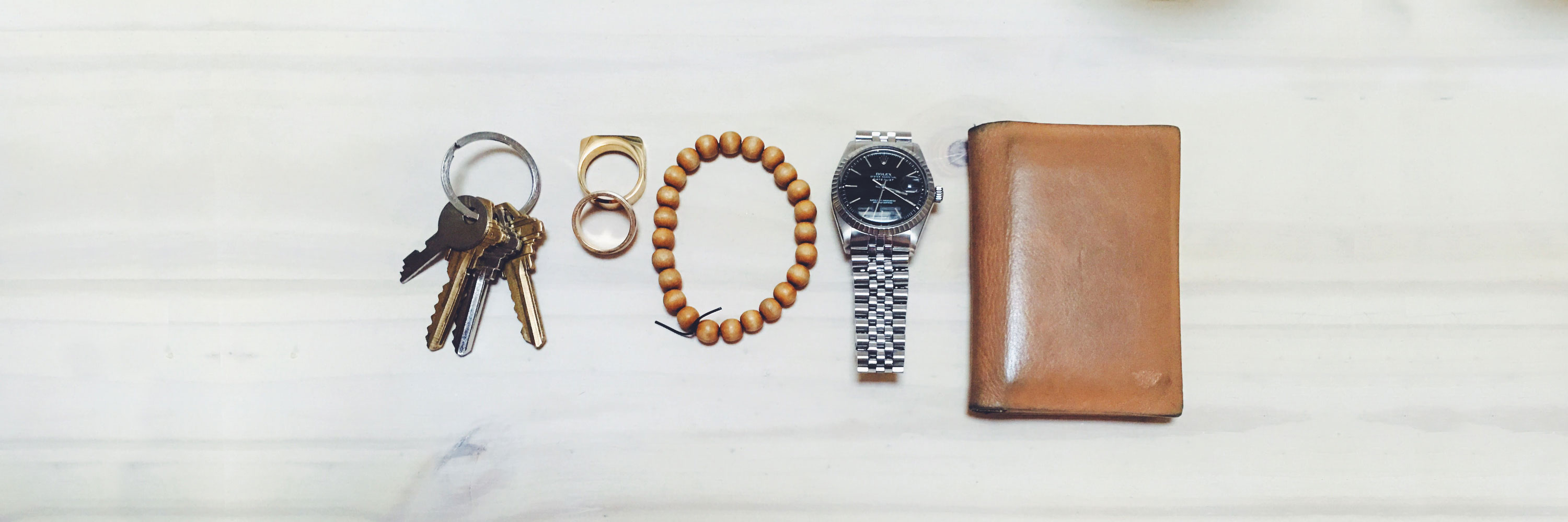 flatlay image of keys, rings, bracelet, watch, and wallet - the typical urban edc kit