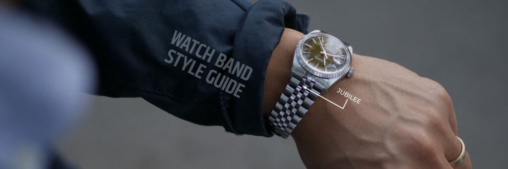 arm with navy jacket sleeve and steel rolex wristwatch