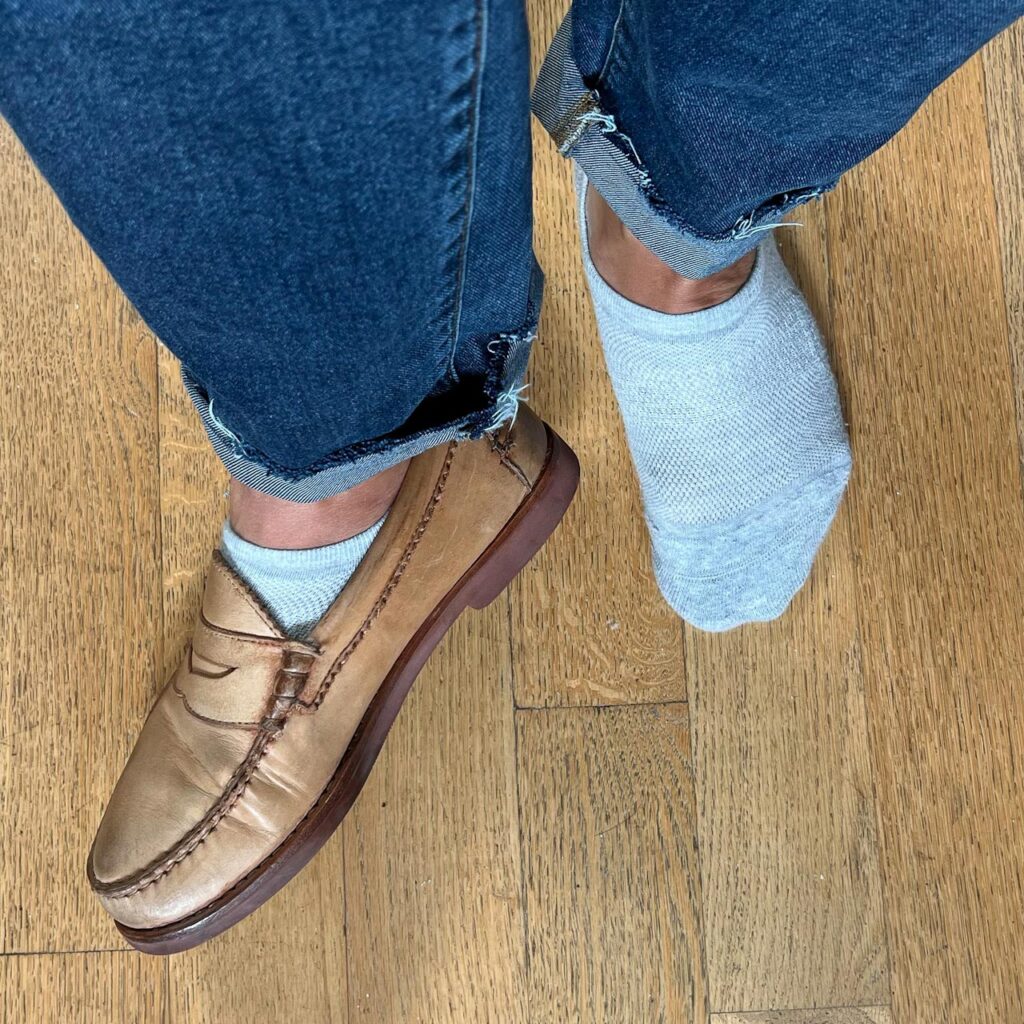 closeup of socks and loafers with one shoe on