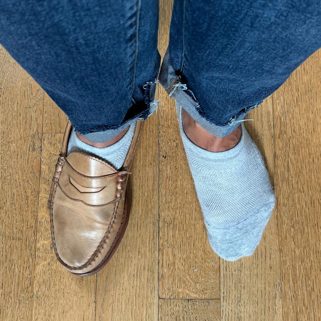 closeup of socks and loafers with one shoe on