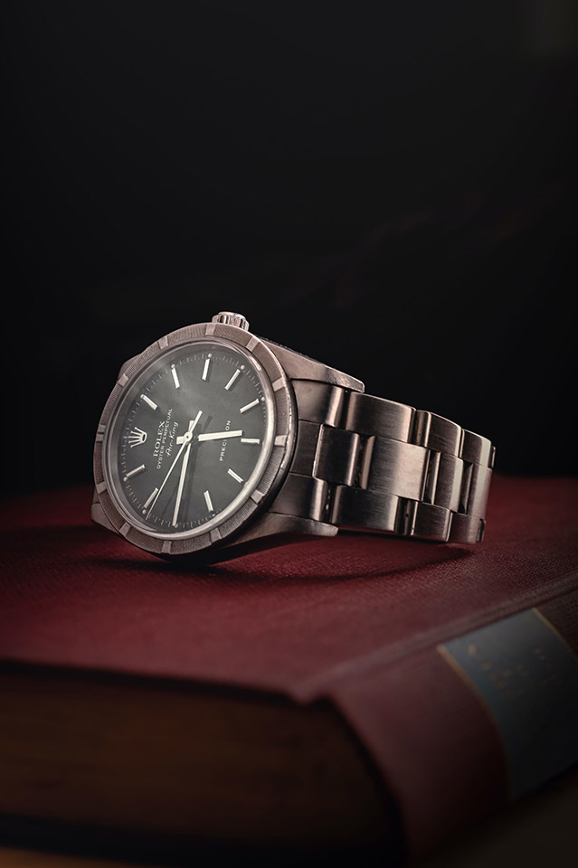best entry level rolex - vintage steel rolex air king set on book closeup with black dial