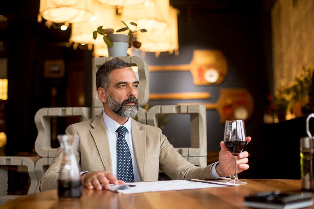 man in tan suit at a restaurant sitting down